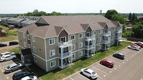 Dieppe apartment for rent - an aerial view of an apartment building with balconies and a parking lot