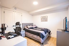 Dieppe townhouse for rent - a bedroom with a bed and a desk and a tv