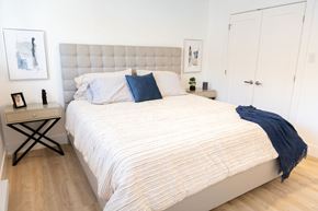 Dieppe townhouse for rent - A bed with a white comforter and a blue pillow is in the image.