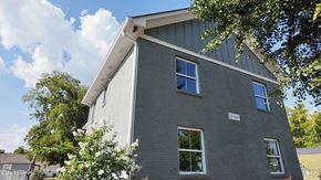 Birmingham apartment for rent - A grey house with a white window and a white sign on the front.