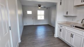 Birmingham apartment for rent - A kitchen with white cabinets and a wooden floor.