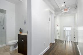 Vancouver apartment for rent - A white bathroom with a toilet, sink, and a wooden floor.