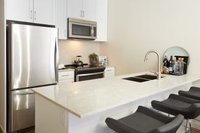 St. Albert apartment for rent - a kitchen with a white counter top and a stainless steel refrigerator