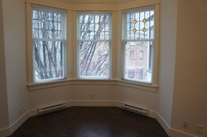 Vancouver apartment for rent - A room with a window overlooking a tree.