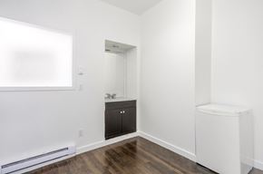 Vancouver apartment for rent - A white bathroom with a wooden floor and a white toilet.