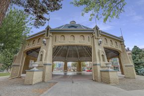 Denver apartment for rent - A gazebo-like structure with a dome roof and arched openings is surrounded by trees.
