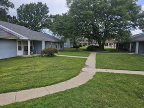 Newton apartment for rent - A grassy area with a walkway and a large tree in the background.