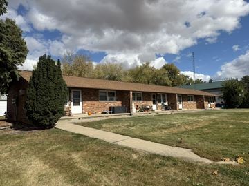 Colfax apartment for rent - A building with a green lawn in front of it.
