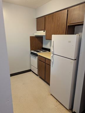 Canton apartment for rent - A white refrigerator stands in a kitchen with wooden cabinets.