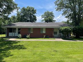 Stonefort apartment for rent - A red brick house with a white door and windows.