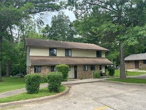Eldorado apartment for rent - A house with a driveway and trees in the background.