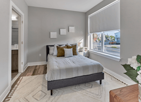 Little Falls apartment for rent - A bedroom with a large bed and a window overlooking the street.