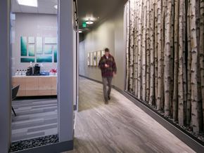 Seattle apartment for rent - a person walking down a hallway with a mural of birch trees