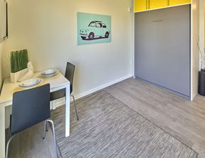 Seattle apartment for rent - a dining room with a table and a painting of a car on the wall