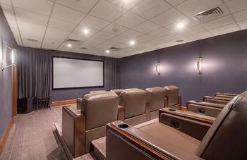 A small conference room with chairs and a screen on the wall