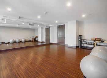 A yoga room with a hard wood floor and a yoga ball