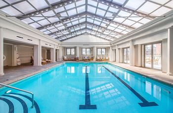 The indoor swimming pool is under a glass ceiling