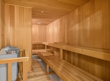 A sauna room with wooden benches and a sink