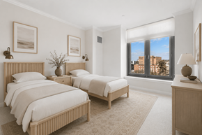 Stamford apartment for rent - A bedroom with two beds and a window overlooking a cityscape.
