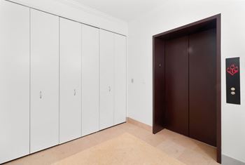 A wardrobe and a door in a white room with a tiled floor