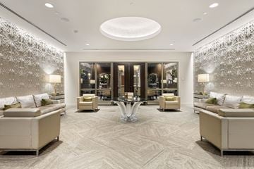 Houston apartment for rent - A spacious living room with a patterned carpet and a large circular ceiling light.