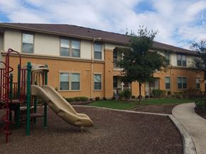 Vidor apartment for rent - A playground with a slide in front of a building.