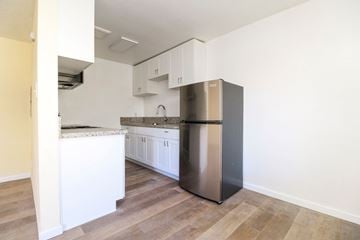 Oakland apartment for rent - A kitchen with a stainless steel refrigerator and white cabinets.