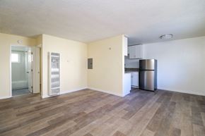 Oakland apartment for rent - A room with wooden flooring and a stainless steel refrigerator.