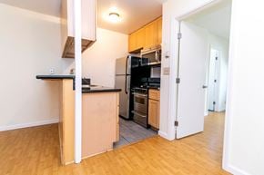 Oakland apartment for rent - A kitchen with black appliances and wooden cabinets.