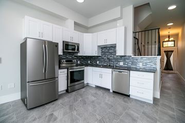Berkeley apartment for rent - A modern kitchen with a stainless steel refrigerator and white cabinets.