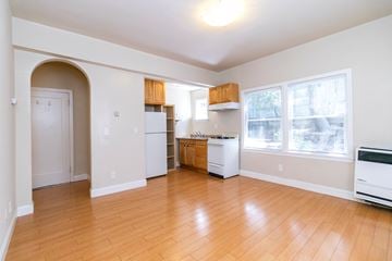 Berkeley apartment for rent - A kitchen with white appliances and wooden floors.