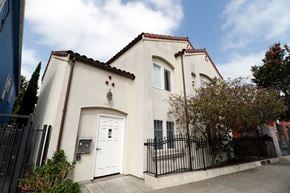 Oakland apartment for rent - A white house with a black gate and a brown roof.