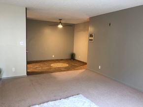 San Diego apartment for rent - an empty living room with a rug and a ceiling fan