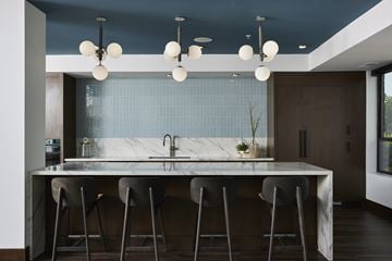 Eden Prairie apartment for rent - A modern kitchen with a marble countertop and bar stools.