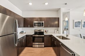 Longmont apartment for rent - A modern kitchen with dark wood cabinets and stainless steel appliances.