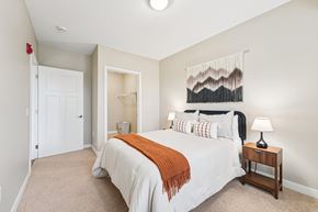 Eden Prairie apartment for rent - A bedroom with a large bed and a wall hanging.