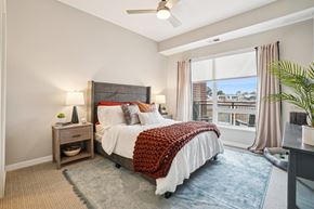 Centennial apartment for rent - A bedroom with a large bed and a ceiling fan.