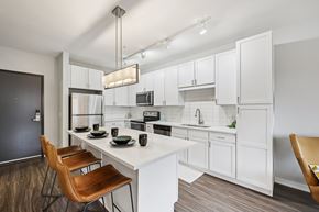 St. Paul townhouse for rent - A modern kitchen with white cabinets and a wooden table.