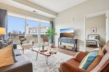 Centennial apartment for rent - A living room with a brown leather couch and a wooden coffee table.
