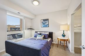 St. Paul townhouse for rent - A bedroom with a large bed and a view of a balcony.