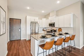 Centennial apartment for rent - A kitchen with a white counter top and brown chairs.