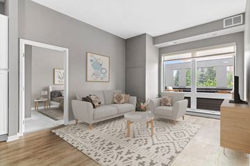 Golden Valley apartment for rent - A living room with a grey couch, a white rug, and a painting on the wall.