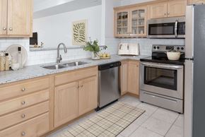Rochester townhouse for rent - a kitchen with wooden cabinets and stainless steel appliances