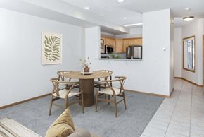 Rochester townhouse for rent - a dining area with a table and chairs and a kitchen in the background