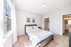 Rochester townhouse for rent - A bedroom with a large bed and a window with curtains.