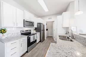 Rochester townhouse for rent - A kitchen with white cabinets and a granite countertop.