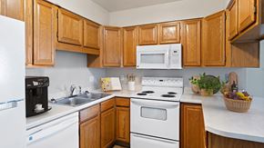 Billings apartment for rent - a kitchen with white appliances and wooden cabinets
