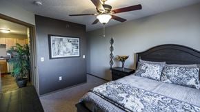 Bismarck apartment for rent - the master bedroom has a large bed and a ceiling fan