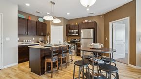 Jamestown apartment for rent - A kitchen with brown cabinets and a white island.