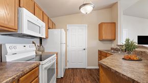 Rapid City apartment for rent - a kitchen with white appliances and wooden cabinets